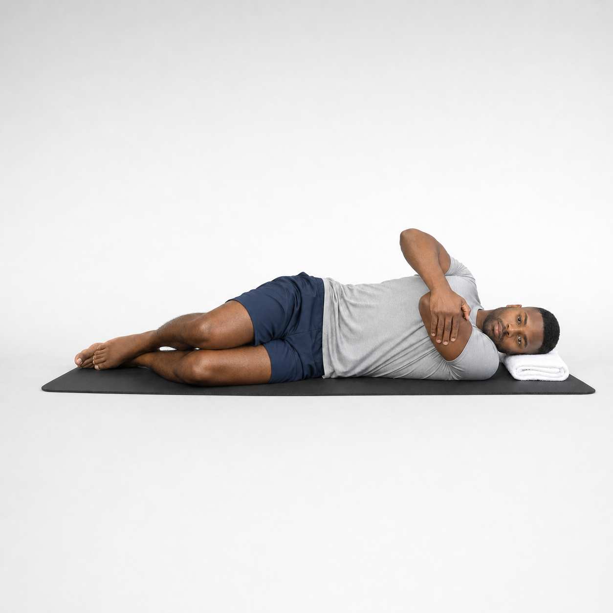 Side-lying cross-body shoulder stretch on a mat