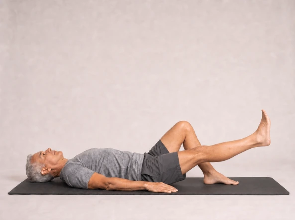Straight exercise leg lowered halfway while remaining off the mat